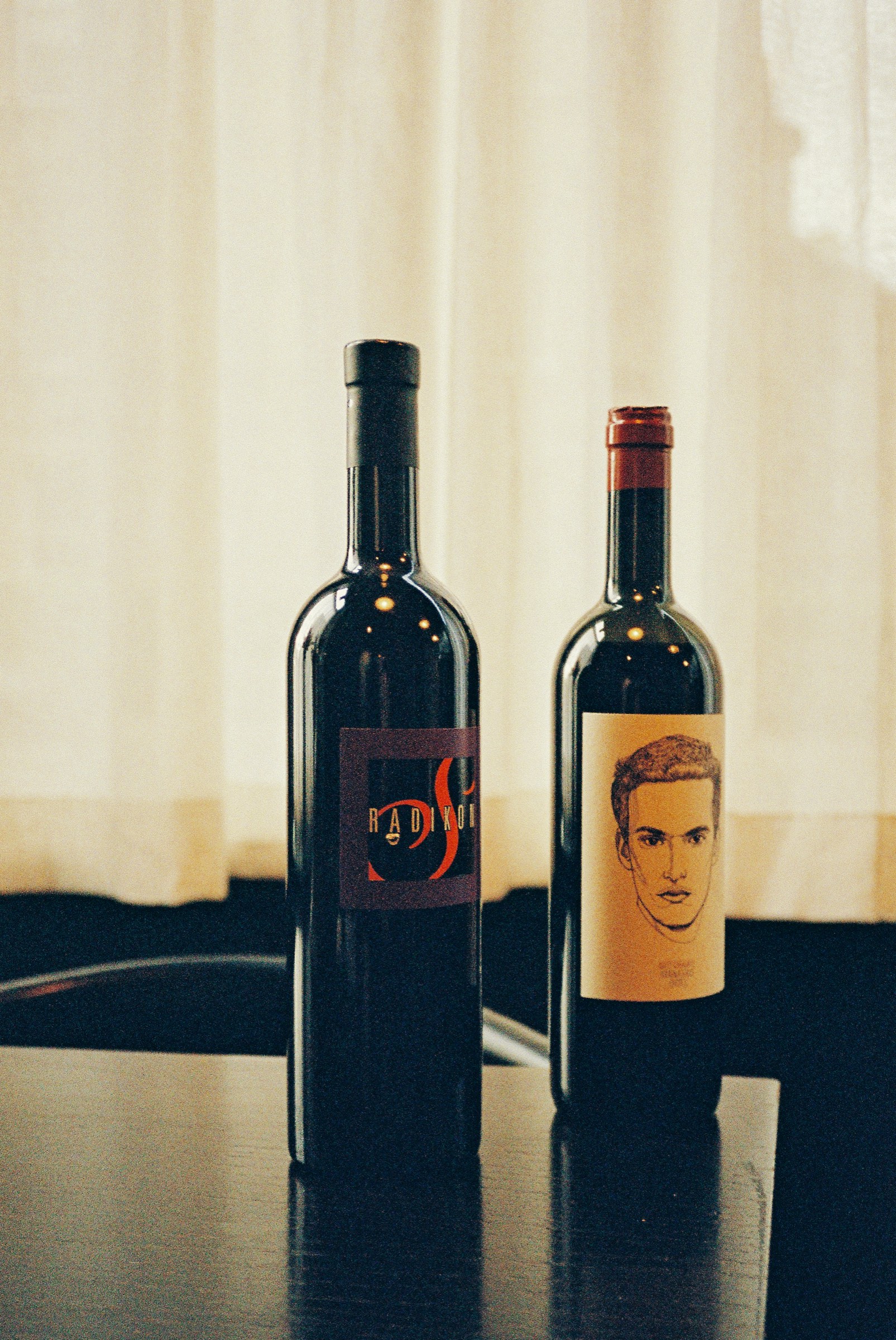 Two bottles from the Cardinal wine list on a table by the window